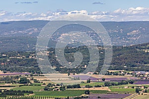 Panoramic view Luberon hills covered with lavender fields, vineyards, apple orchards, forests from top of historic hill villageÂ 